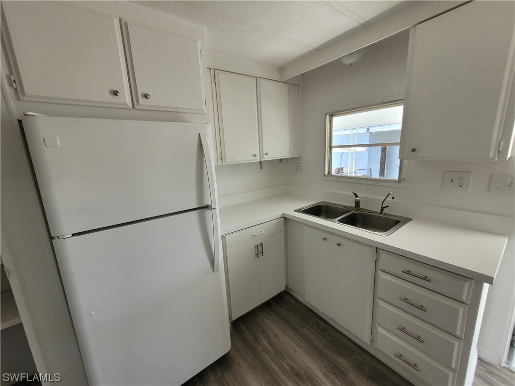 a kitchen with sink cabinets and white appliances