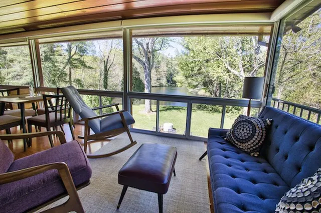 a living room with furniture and a floor to ceiling window