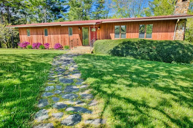 a front view of house with yard and green space