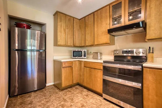 a kitchen with stainless steel appliances granite countertop a refrigerator stove and sink