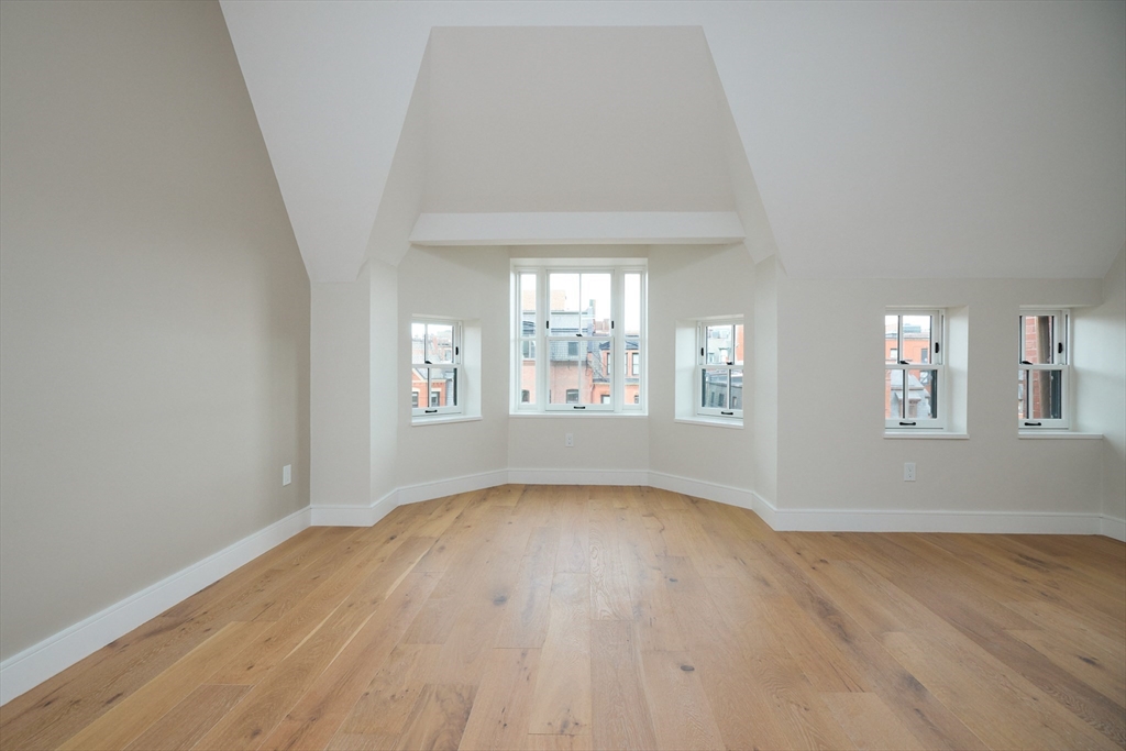 246 Newbury Street, Unit PH Boston, MA 02116 - Photo 15 of 22 wooden floor in an empty room with a window