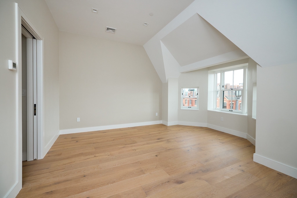 246 Newbury Street, Unit PH Boston, MA 02116 - Photo 16 of 22 a view of an empty room with wooden floor and a window
