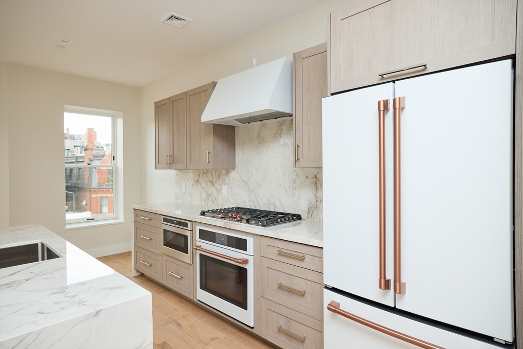 246 Newbury Street, Unit PH Boston, MA 02116 - Photo 8 of 22 a kitchen with stainless steel appliances a stove and a refrigerator