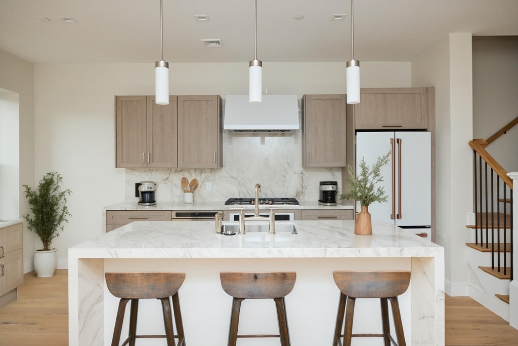 246 Newbury Street, Unit PH Boston, MA 02116 - Photo 9 of 22 a kitchen with stainless steel appliances a sink a stove a refrigerator and cabinets