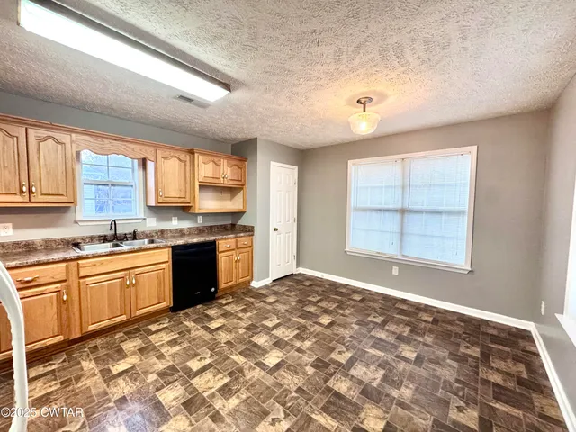 a large kitchen with kitchen island granite countertop a sink and a stove top oven