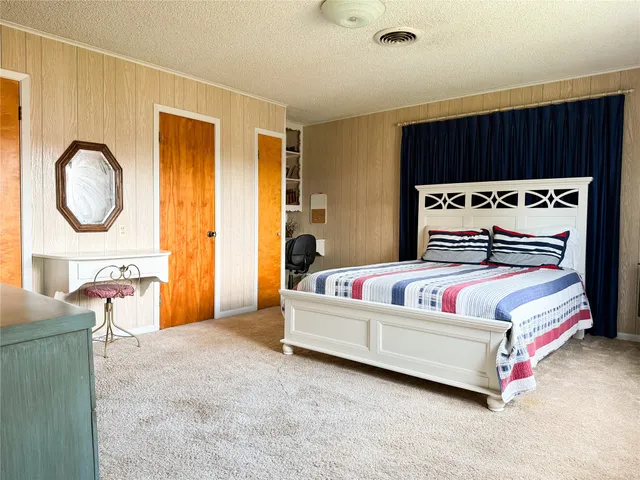 a bedroom with a bed a mirror and a dresser