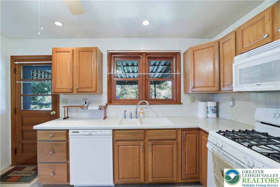 1539 Spring Garden Street Wilson, PA 18042 - Photo 13 of 34 Warm wood cabinetry pairs with ample counter space and classic tile backsplash elements.