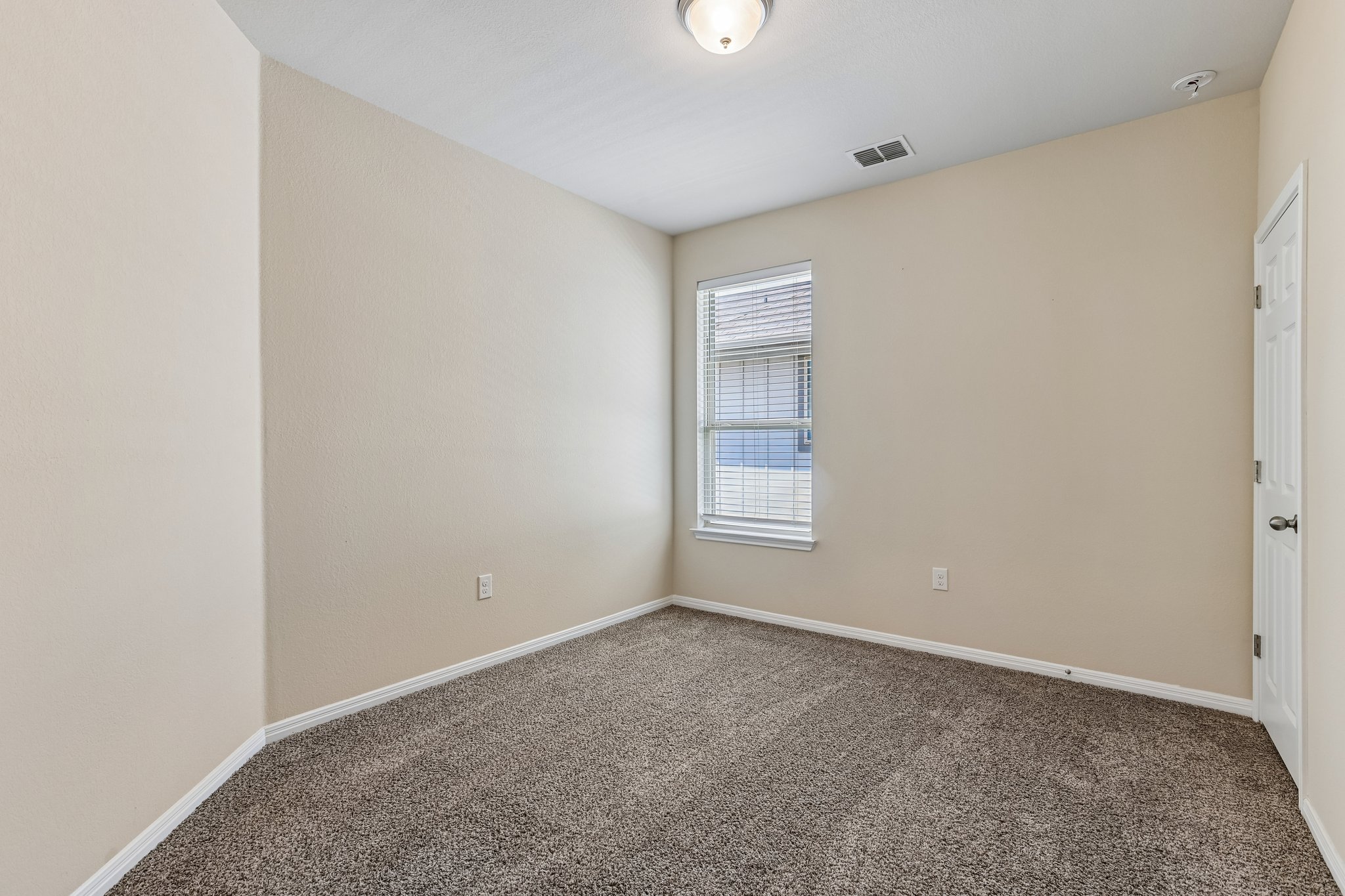 808 Totis Road Austin, TX 78748 - Photo 26 of 40 Carpeted room featuring a single window with blinds, a white paneled door, and a flush mount ceiling light