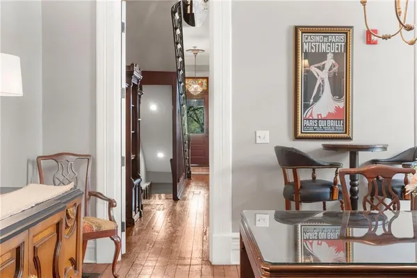 a view of dining room and livingroom with furniture wooden floor a rug a painting and a chandelier