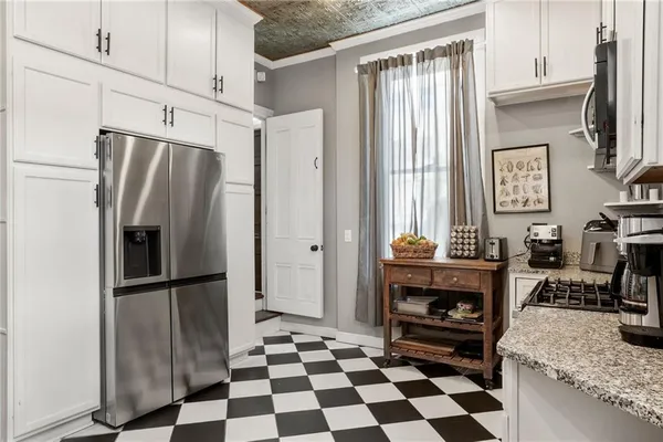 a kitchen with granite countertop a refrigerator and a stove top oven