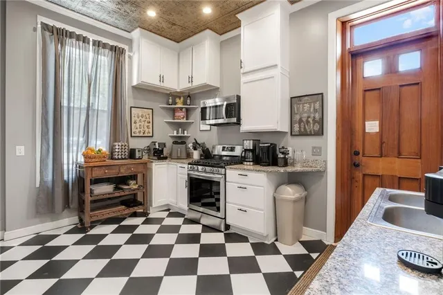 a kitchen with stainless steel appliances granite countertop a refrigerator and a stove top oven