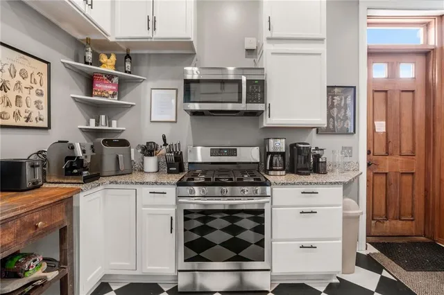 a kitchen with stainless steel appliances granite countertop a stove and cabinets