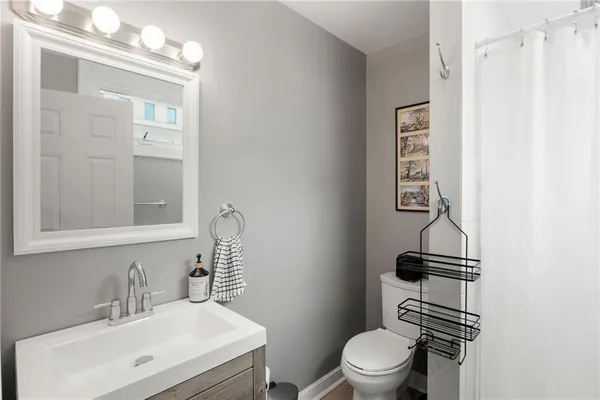 a bathroom with a toilet a sink and mirror