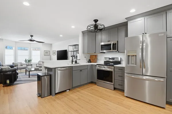 a kitchen with a refrigerator a stove top oven a sink dishwasher and wooden cabinets