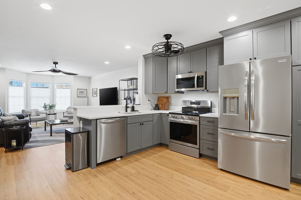 25 Greeley Street, Unit 2 Clinton, MA 01510 - Photo 11 of 33 a kitchen with a refrigerator a stove top oven a sink dishwasher and wooden cabinets