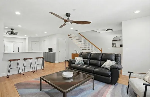 a living room with furniture and a wooden floor