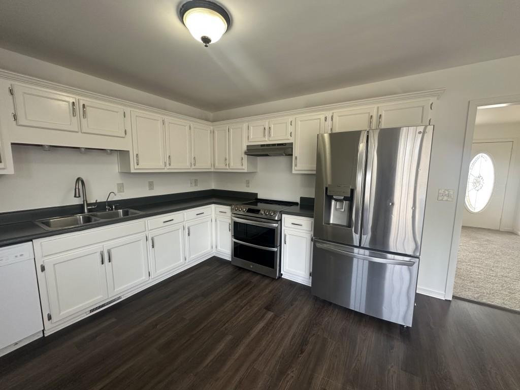 205 Daisy Lane Chatsworth, GA 30705 - Photo 12 of 34 a kitchen with granite countertop a refrigerator stove and wooden floor