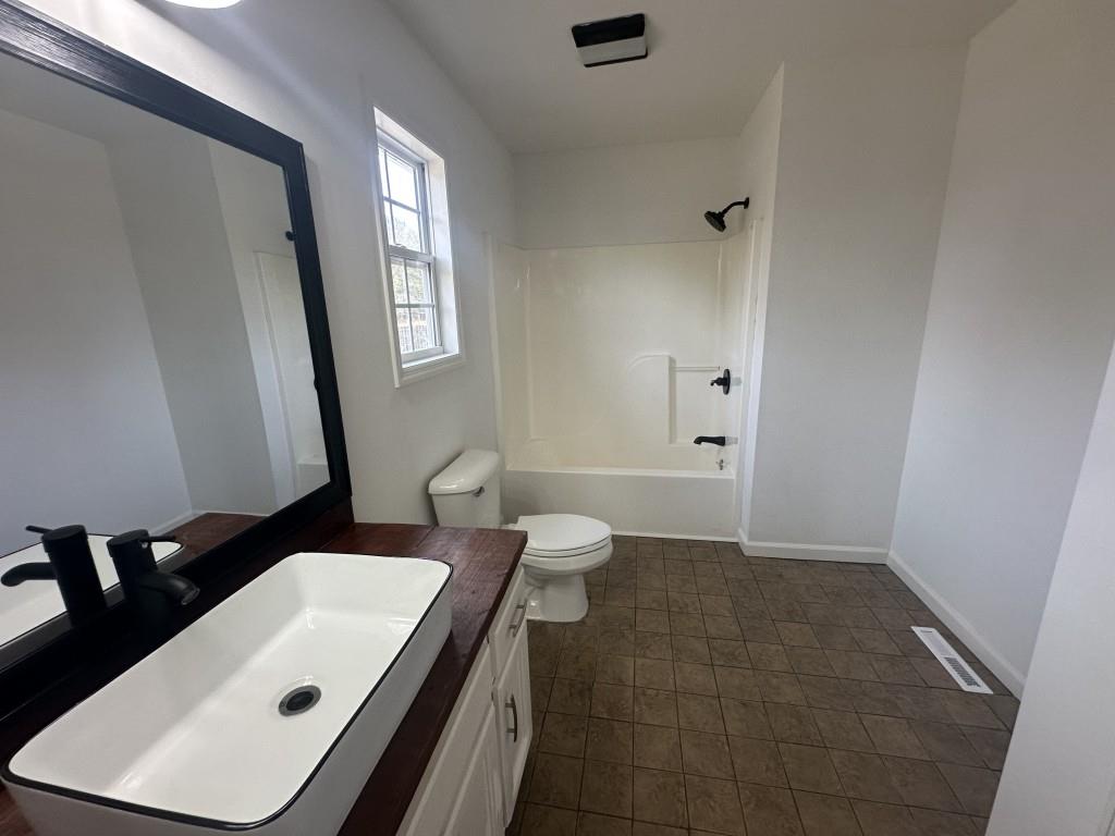 205 Daisy Lane Chatsworth, GA 30705 - Photo 21 of 34 a bathroom with a sink a toilet a mirror and vanity