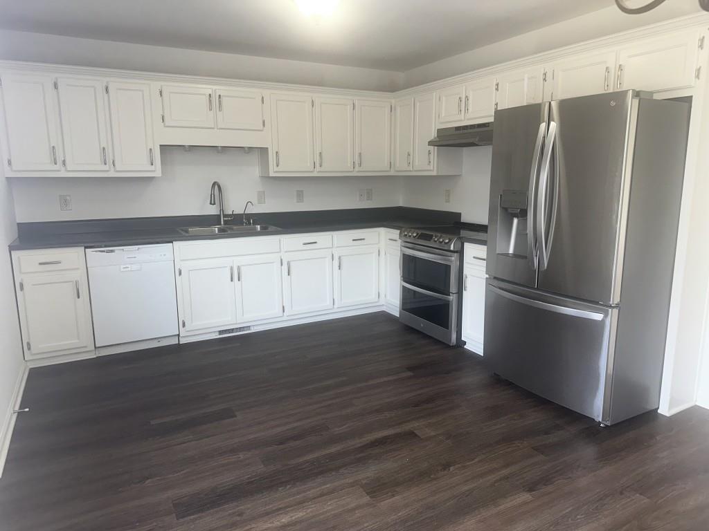 205 Daisy Lane Chatsworth, GA 30705 - Photo 10 of 34 a kitchen with granite countertop a refrigerator stove and white cabinets
