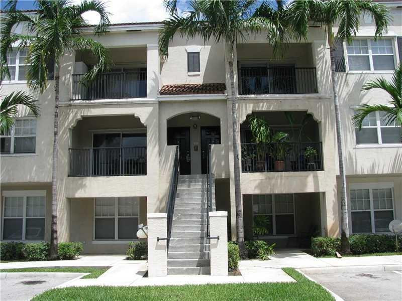 5800 West Sample Road, Unit 305 Coral Springs, FL 33067 - Photo 1 of 28 a front view of a house with a yard and garage