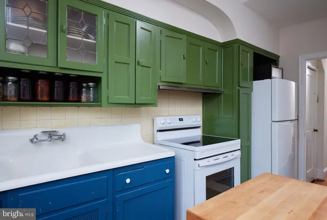 a kitchen with stainless steel appliances white cabinets and a refrigerator