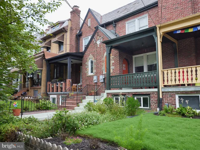 front view of a brick house with a yard