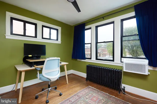 a view of a workspace with furniture and a window