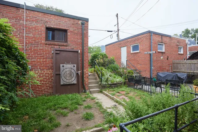 a backyard of a house with chairs and plants