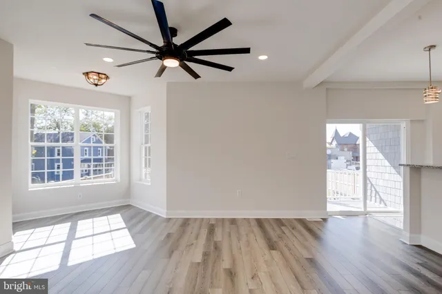 a view of an empty room with wooden floor and closet