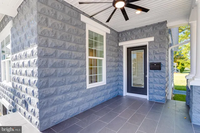 a view of a room with wooden floor and a ceiling fan