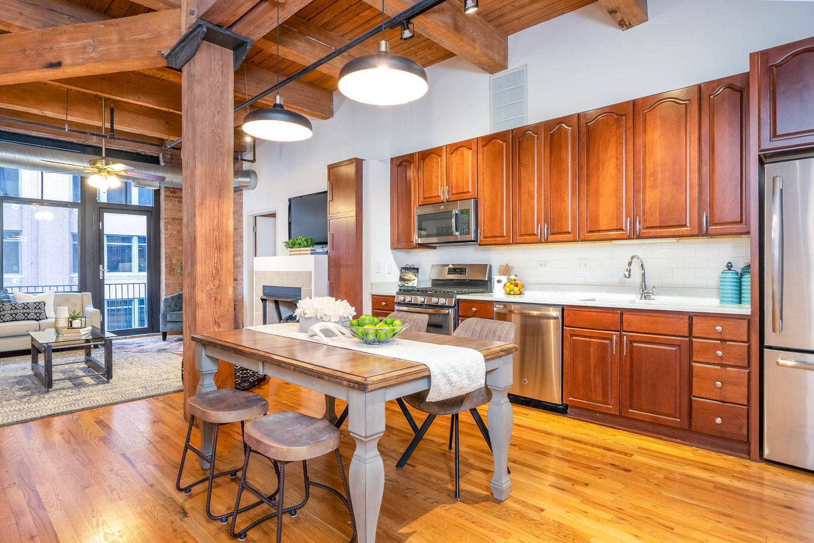 625 West Jackson Boulevard, Unit 313 Chicago, IL 60661 - Photo 3 of 33 a kitchen with stainless steel appliances granite countertop wooden cabinets a dining table and chairs