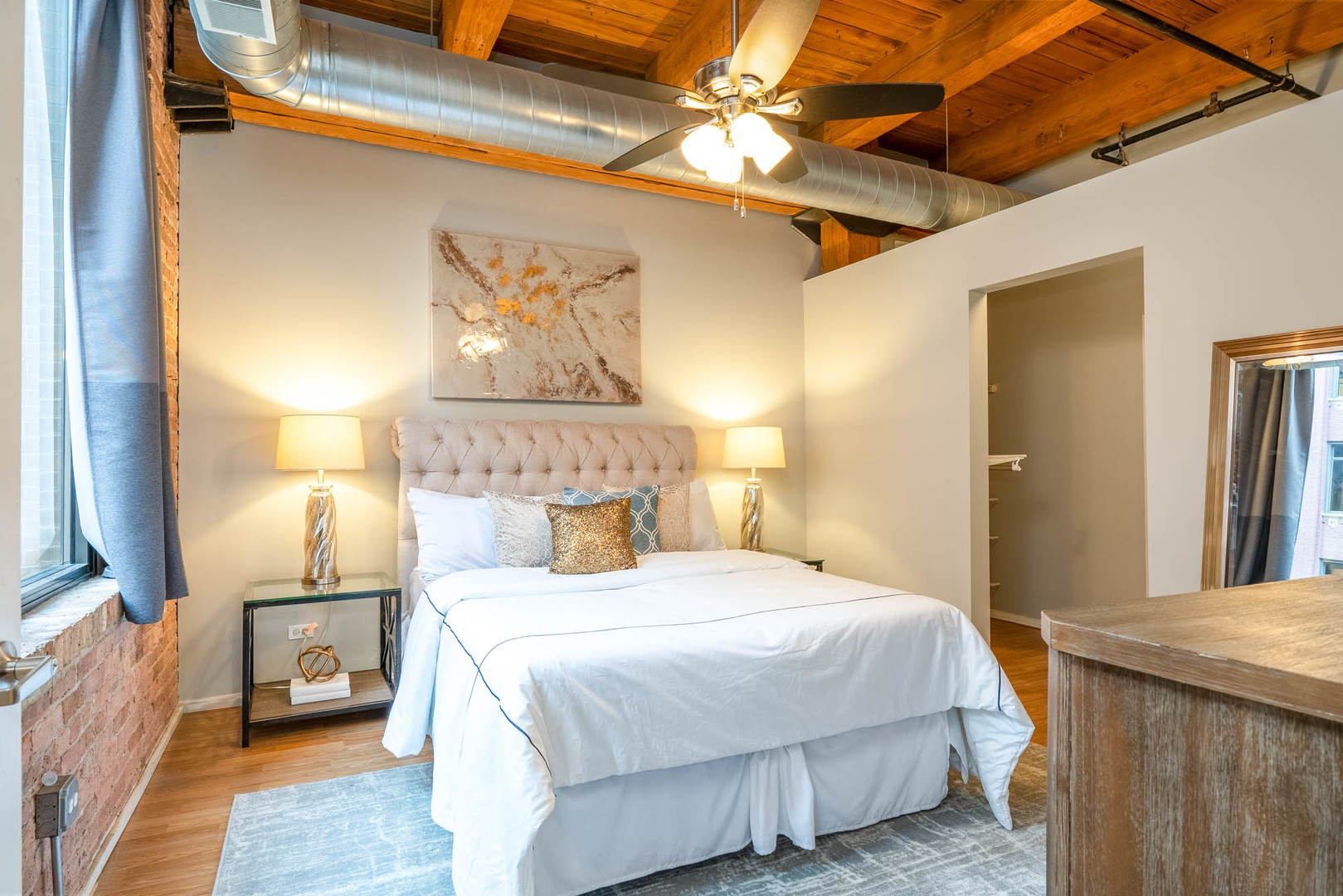 625 West Jackson Boulevard, Unit 313 Chicago, IL 60661 - Photo 7 of 33 a bedroom with a bed and a chandelier