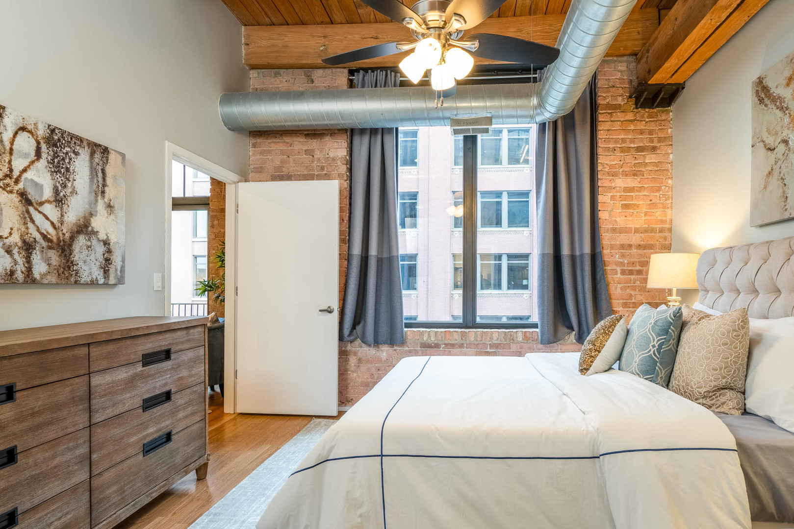 625 West Jackson Boulevard, Unit 313 Chicago, IL 60661 - Photo 9 of 33 a bedroom with a large bed and a window