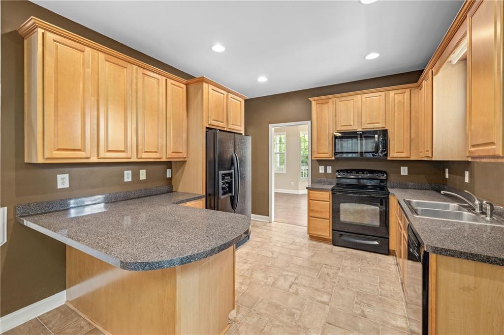 7913 Pea Ridge Road Lula, GA 30554 - Photo 11 of 51 a kitchen with stainless steel appliances granite countertop a refrigerator a stove top oven a sink and dishwasher