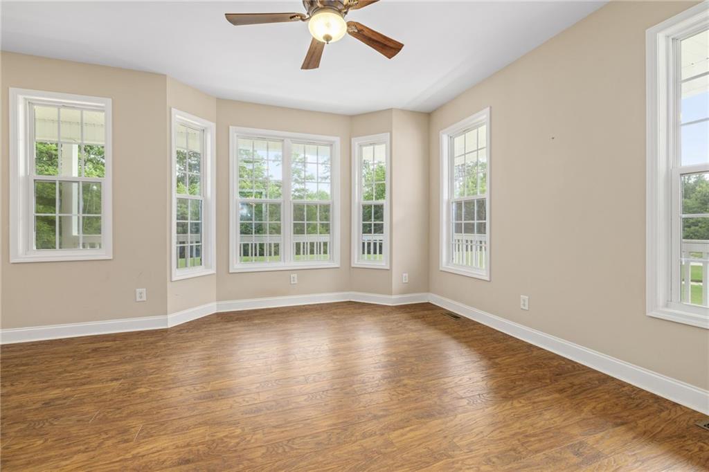 7913 Pea Ridge Road Lula, GA 30554 - Photo 8 of 51 a view of an empty room with wooden floor and a window