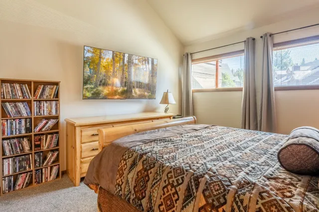 a bed sitting in a bedroom next to a book shelf