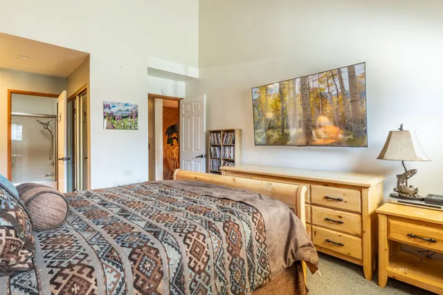 a bedroom with a bed and a dresser next to a window
