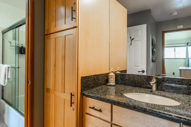 a bathroom with a granite countertop sink and a mirror