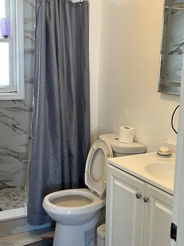 a bathroom with a sink a toilet and a mirror