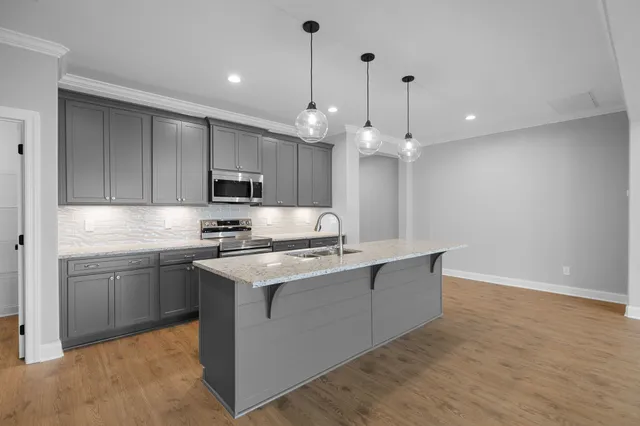 a kitchen with kitchen island a sink stainless steel appliances and cabinets