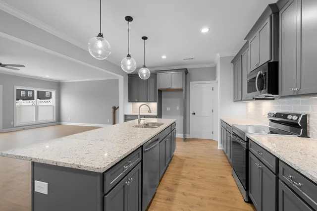 a large kitchen with granite countertop a large counter top space appliances and cabinets