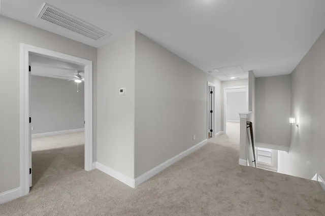 an empty room with windows and chandelier fan