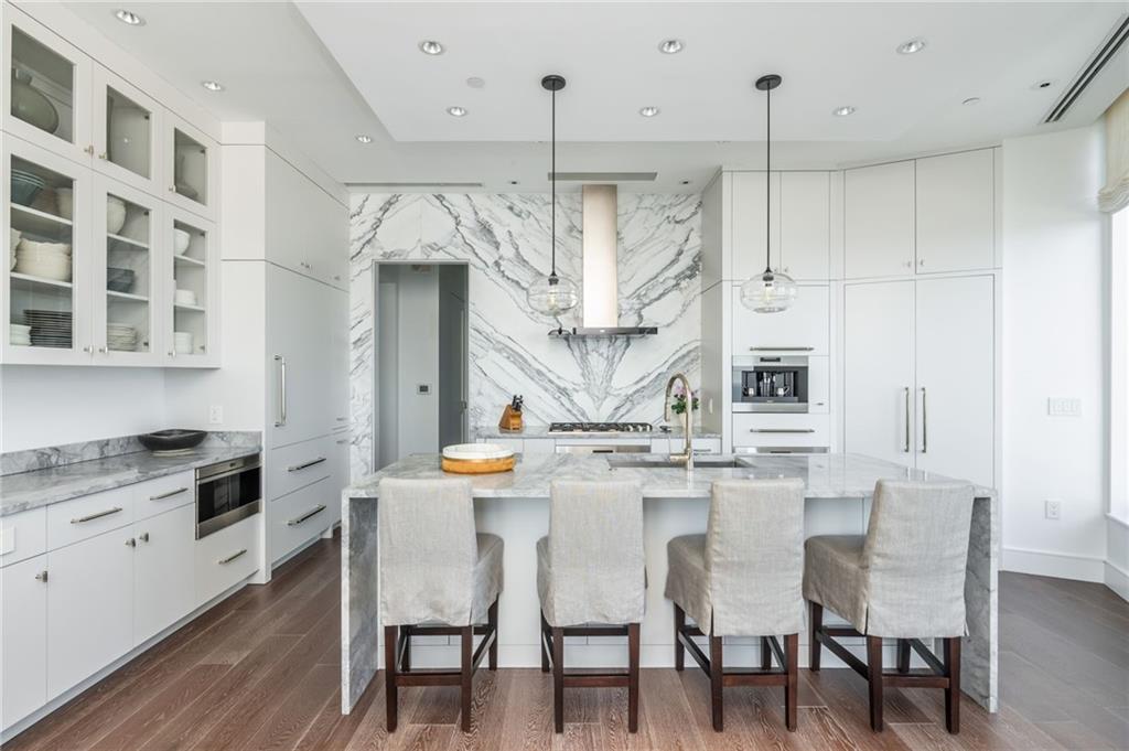 3376 Peachtree Road Northeast, Unit PH51 Atlanta, GA 30326 - Photo 16 of 43 a kitchen with stainless steel appliances kitchen island granite countertop a table chairs and white cabinets