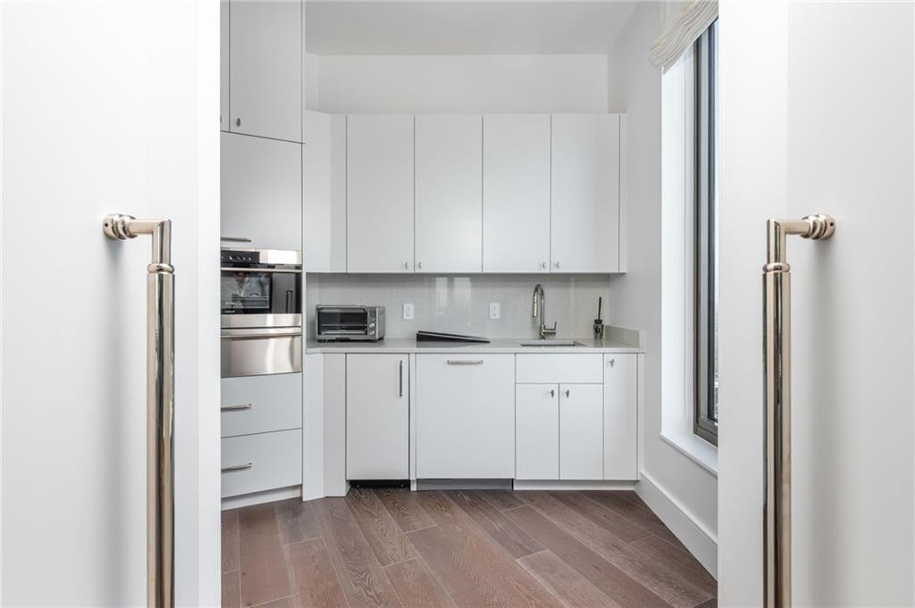 3376 Peachtree Road Northeast, Unit PH51 Atlanta, GA 30326 - Photo 21 of 43 a kitchen with white cabinets and white appliances