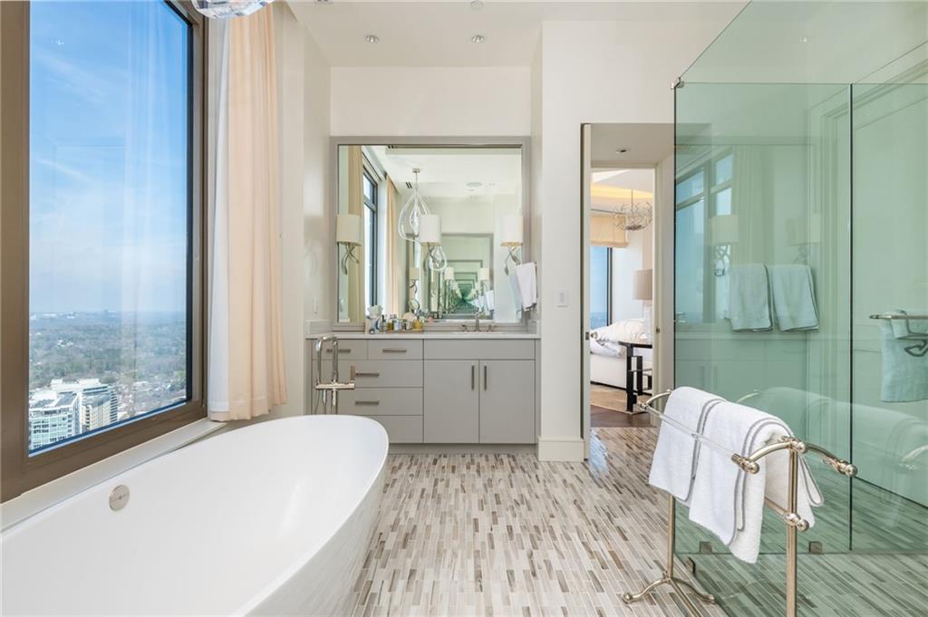 3376 Peachtree Road Northeast, Unit PH51 Atlanta, GA 30326 - Photo 33 of 43 a spacious bathroom with a tub sink and mirror