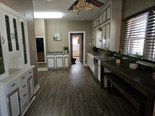a kitchen with stainless steel appliances a sink dishwasher stove and wooden floor