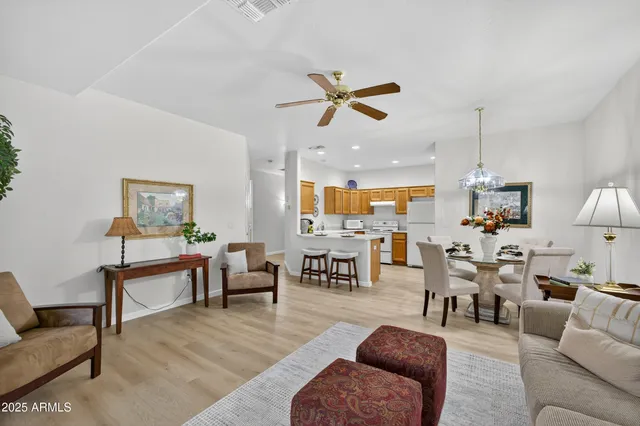 a living room with furniture kitchen view and a chandelier
