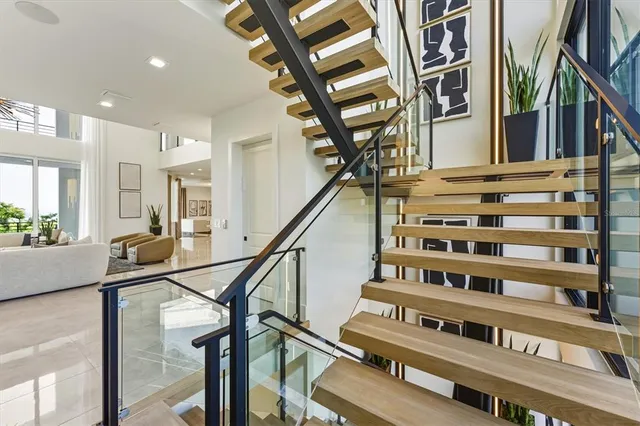a living room with furniture a rug potted plant and a large window