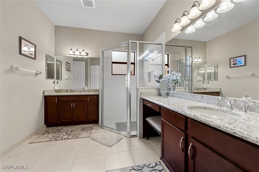 11652 Meadowrun Circle Fort Myers, FL 33913 - Photo 17 of 38 a bathroom with a granite countertop sink a mirror and a shower
