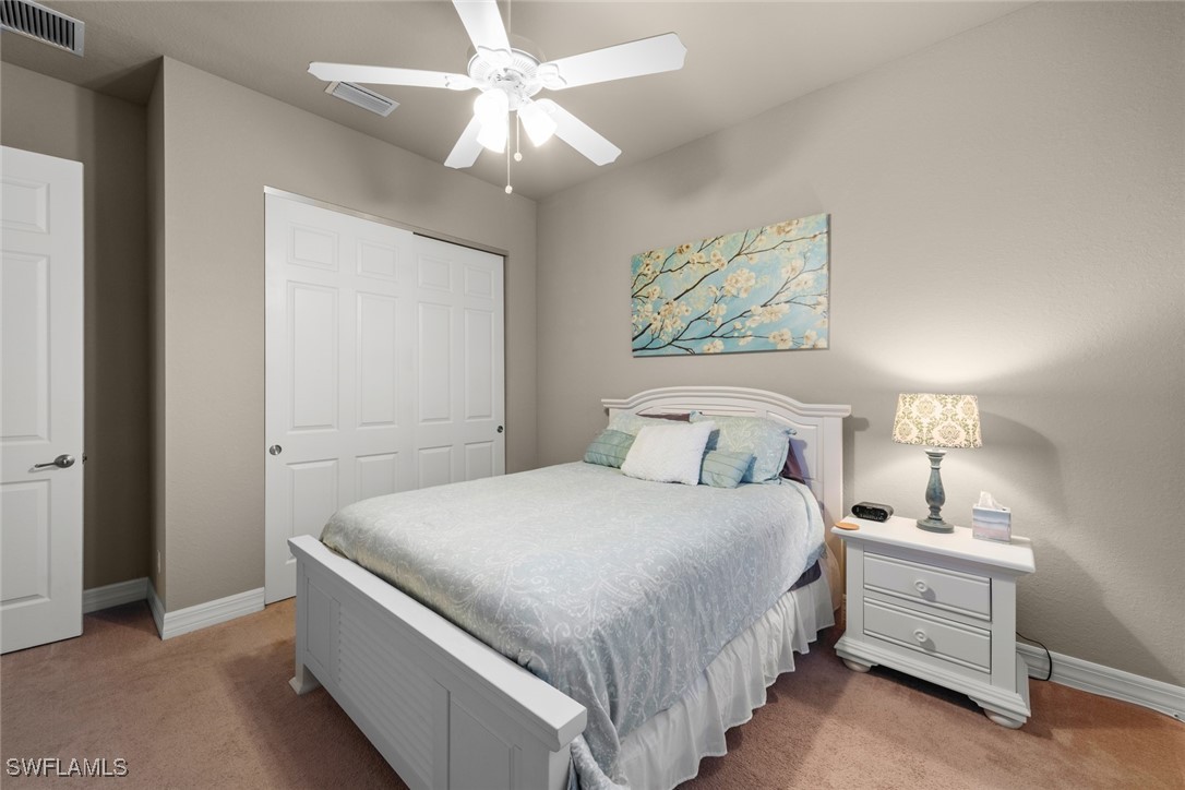 11652 Meadowrun Circle Fort Myers, FL 33913 - Photo 23 of 38 a bedroom with a large bed and a chandelier